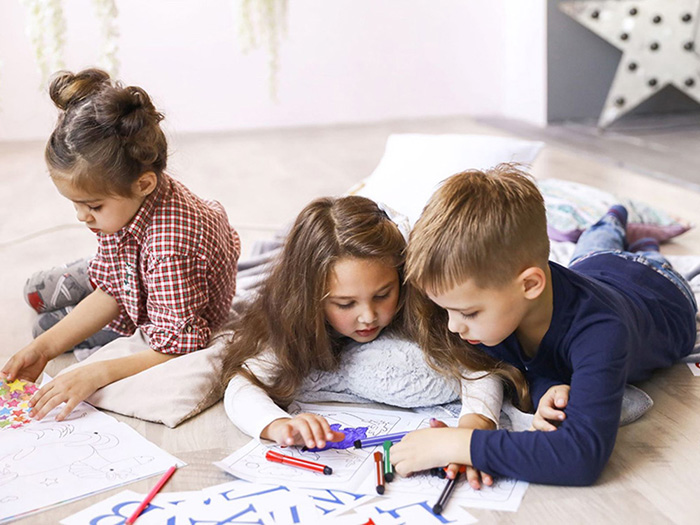three-focused-children-are-playing-floor-drawing-coloring-books-Copy.jpg